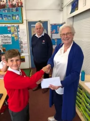 Penelope receiving a donation from one of the pupils